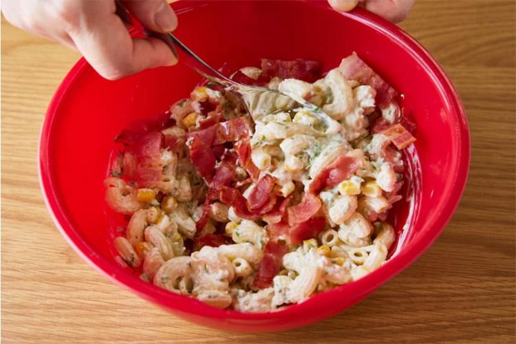 マカロニ、ベーコン、マヨネーズ、牛乳、コーン、調味料を混ぜ合わせる