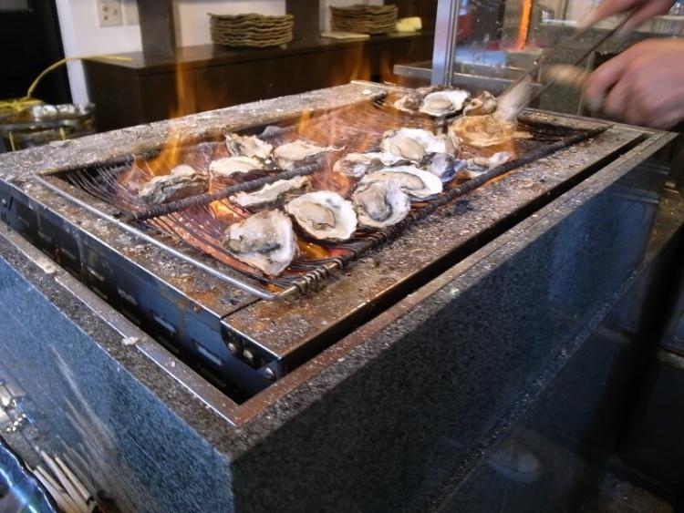 ▲宮島の牡蠣屋。軒先で殻付きの牡蠣を炙っている牡蠣の専門店