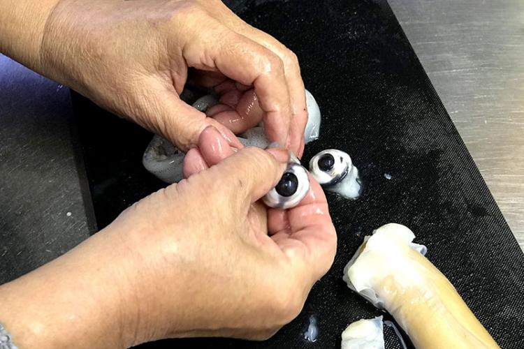 イカの目を指で引っ張って取り除く