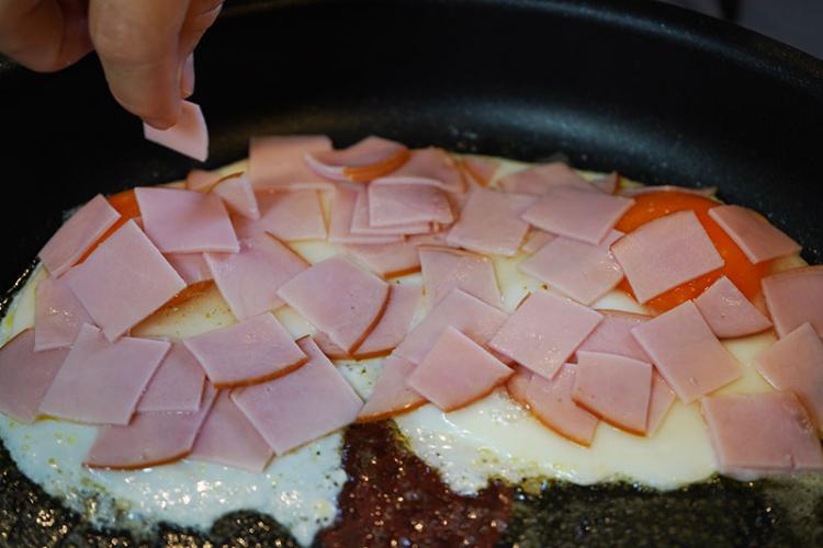 卵の片面を焼いてる時に切ったハムを載せる