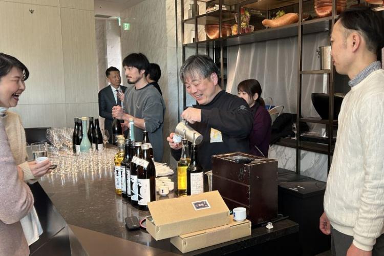 燗での試飲をすすめる剣菱酒造の白樫政孝社長（中央）