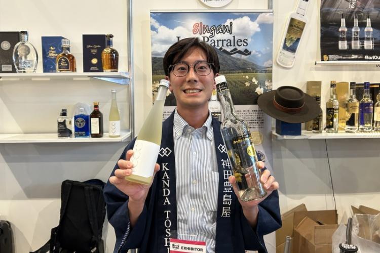片手にシンガニ(ボリビア産のホワイトブランデー)を持つ豊島屋のスタッフ