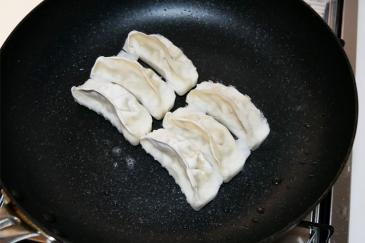 ①フライパンに油をひかずに凍ったままの餃子を並べ、火をつける